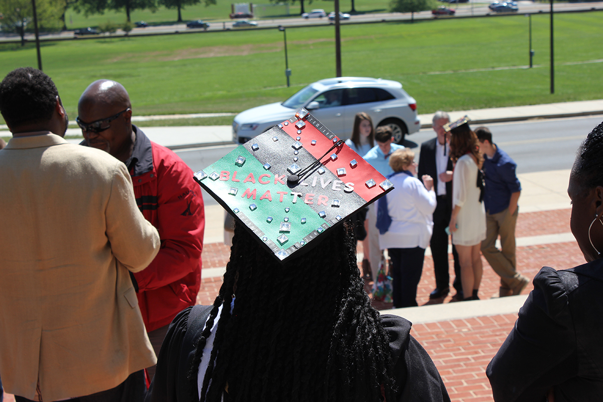 A student after graduation ceremony wearing a hat that says Black Lives Matter