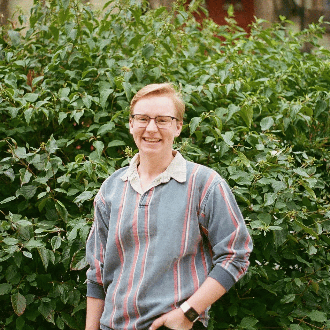 Jordan standing in front of a large bush