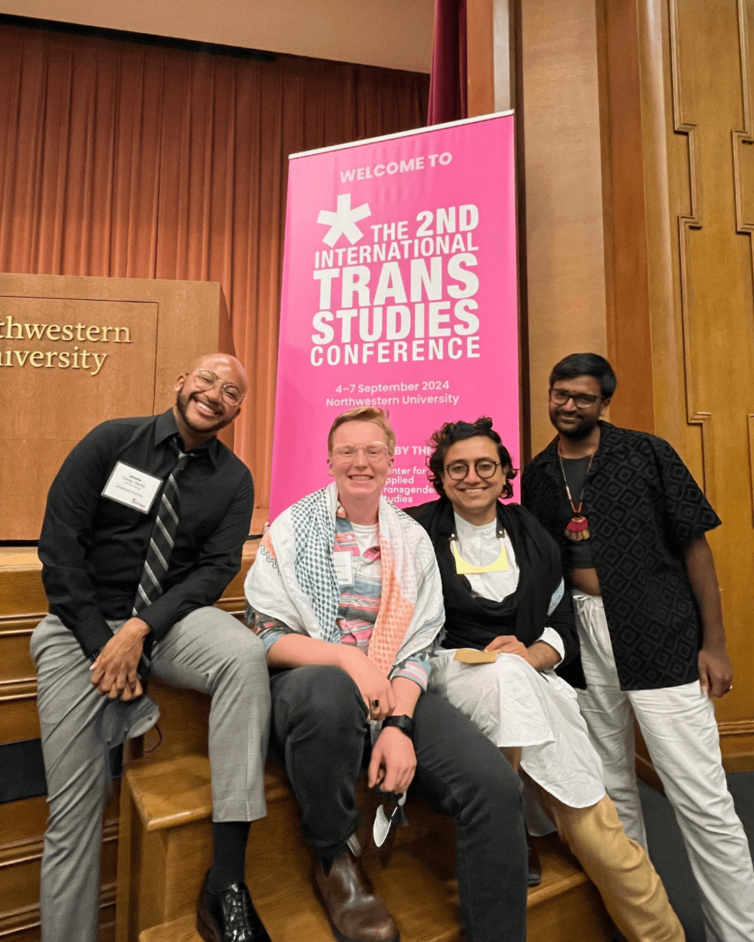 Four individuals pose with the sign for the 2nd Annual Trans Studies Conference