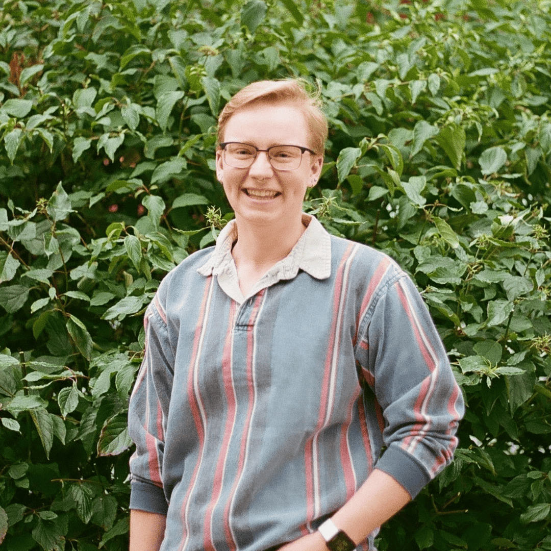 Headshot of Jordan Keesler, a white person with light hair wearing glasses and a striped sweater